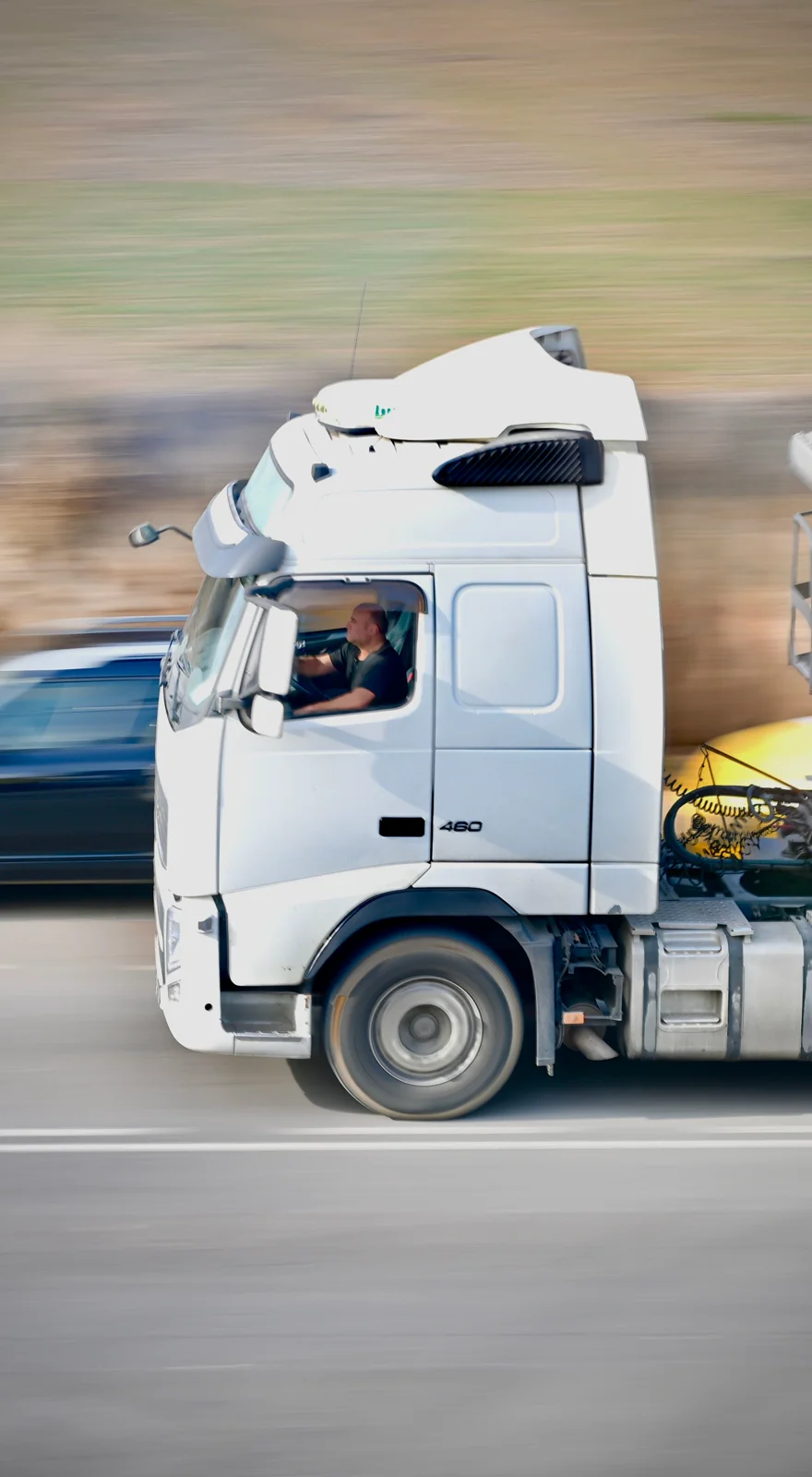 A professional driver at the wheel of a moving truck
