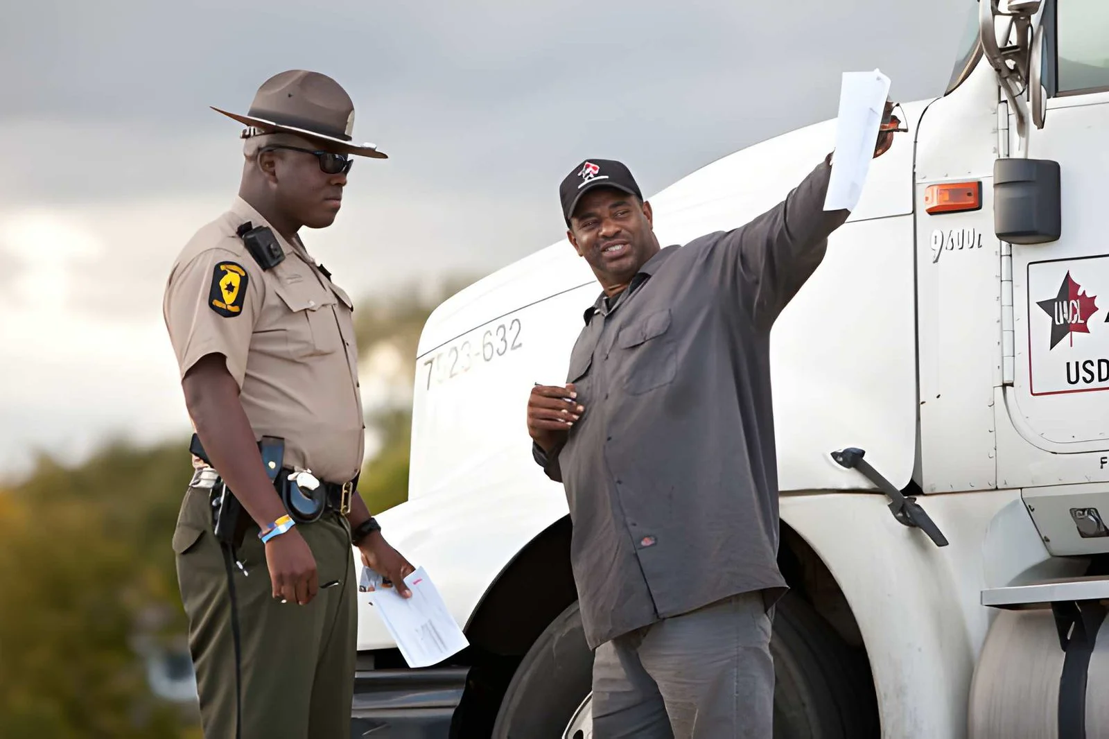 A roadside officer and truck driver reviewing documents